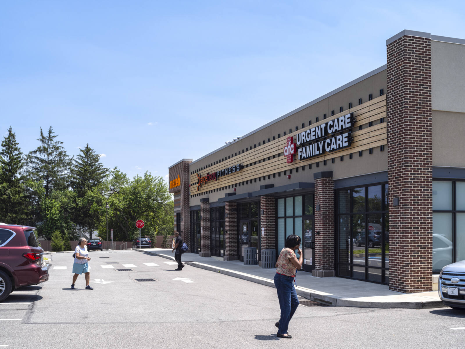 afc Urgent Care with patrons entering and exiting via the parking lot.