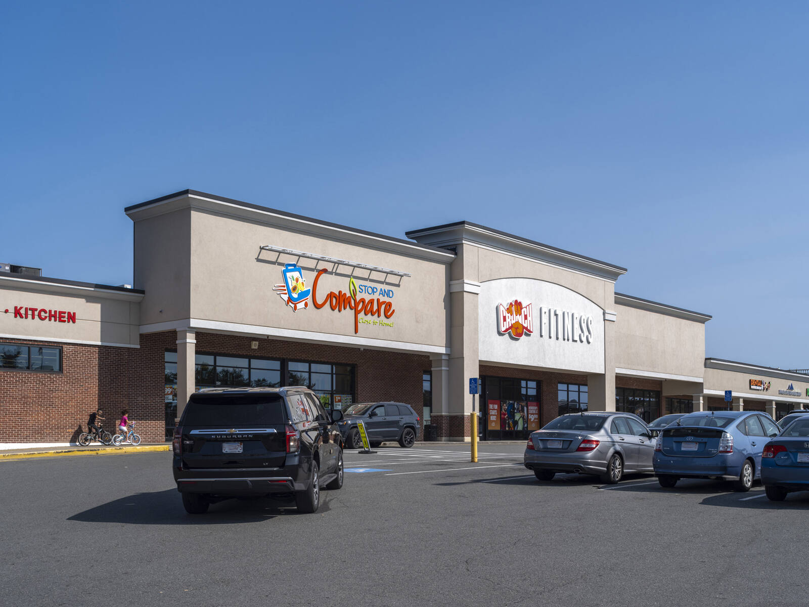 Busy parking lot in front of Stop and Compare and Crunch Fitness.