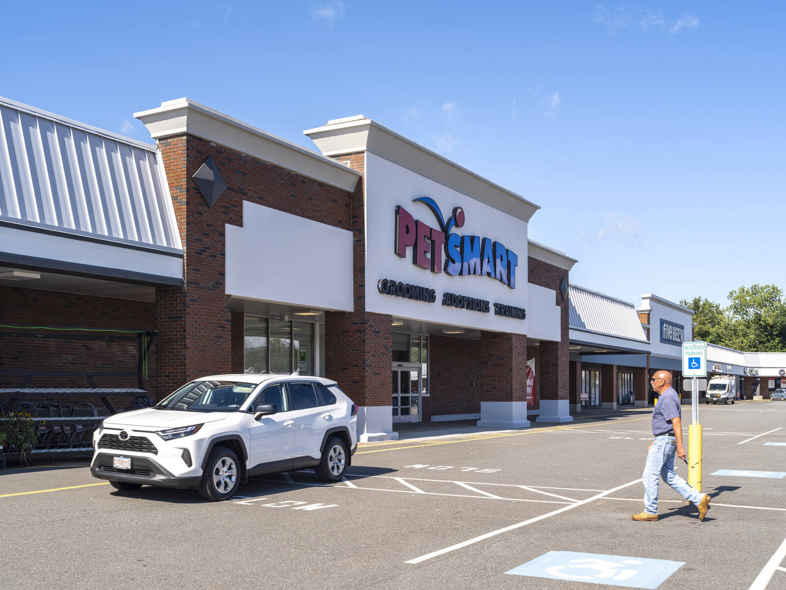 White SUV and pedestrian in front of PetSmart.