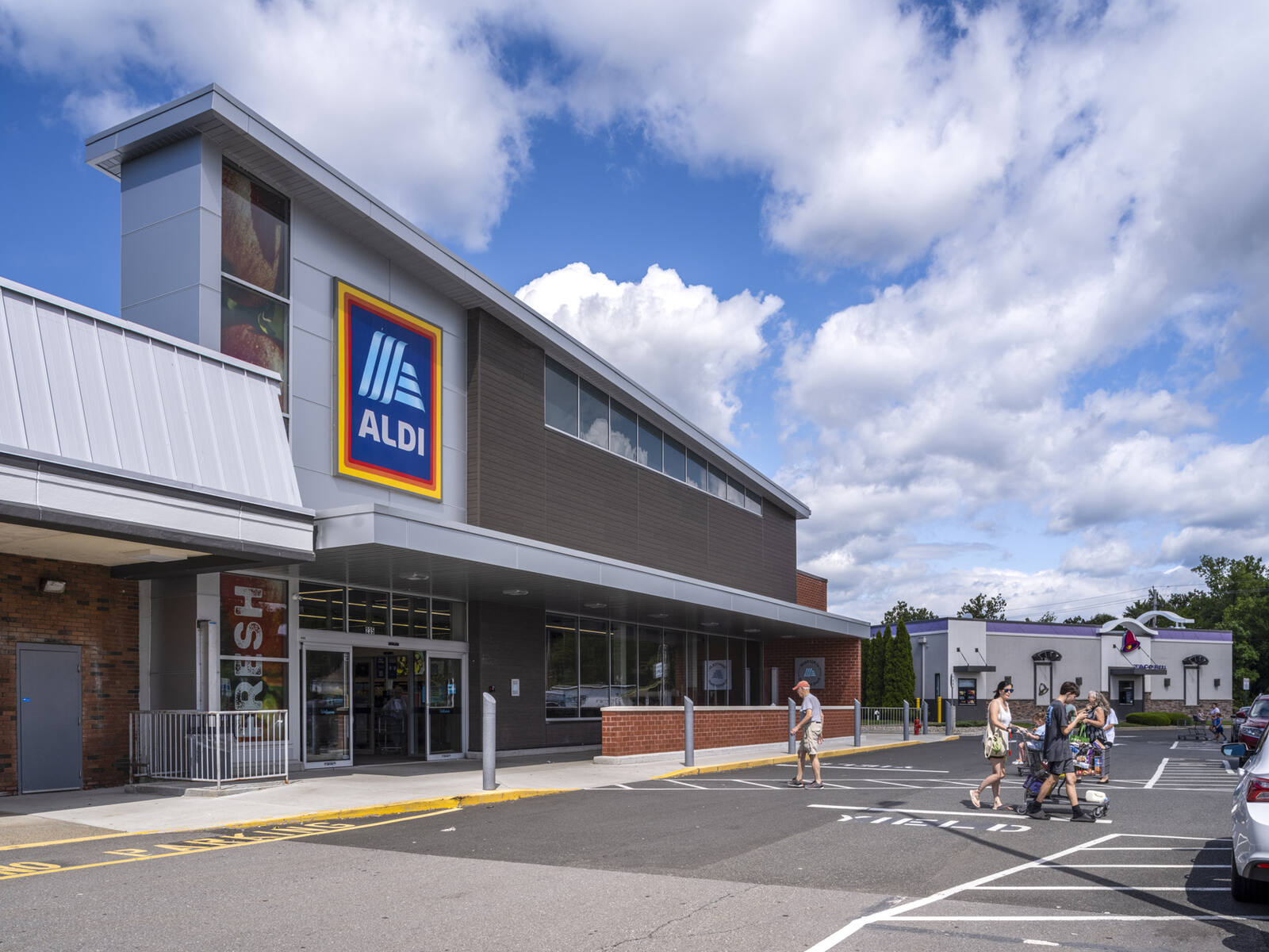 Shoppers in crosswalk of Aldi supermarket.
