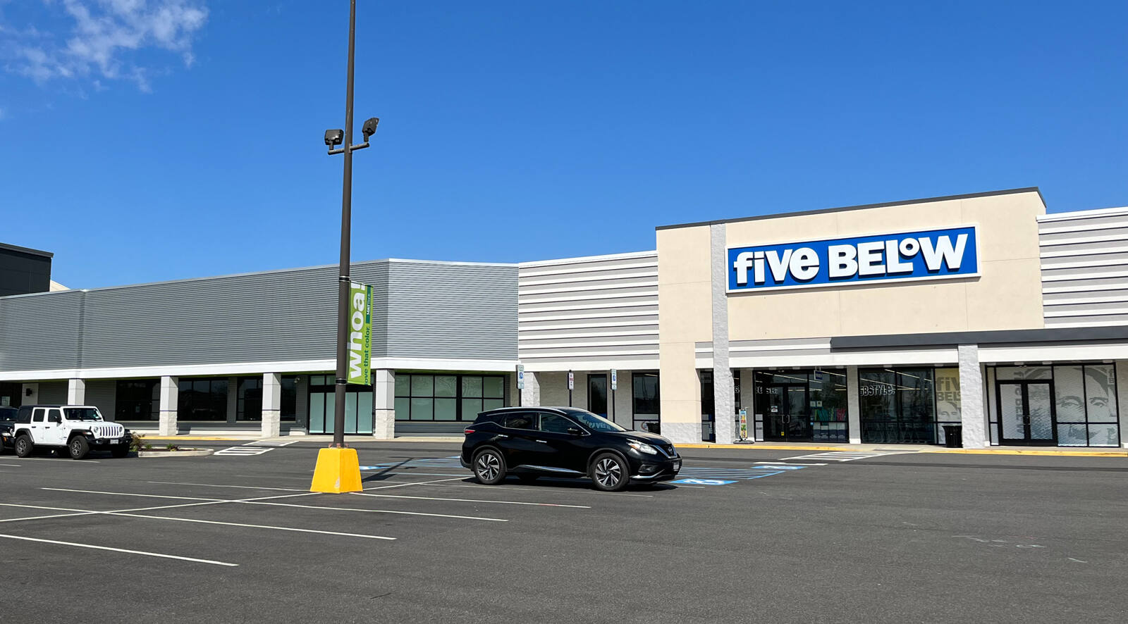 Black SUV parked in front of Five Below store.