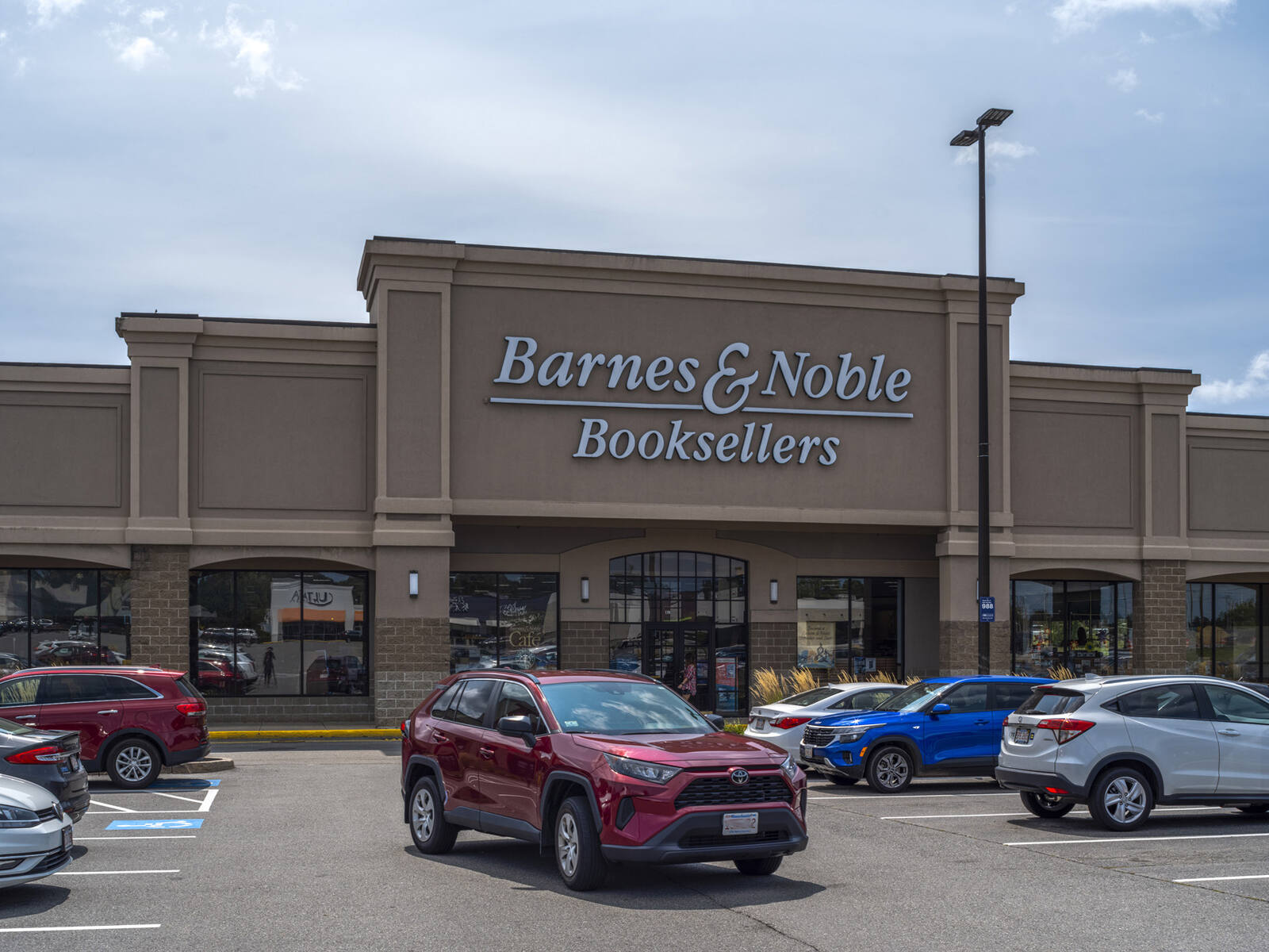 Red SUV pulling out of parking lot at a busy Barnes & Noble.