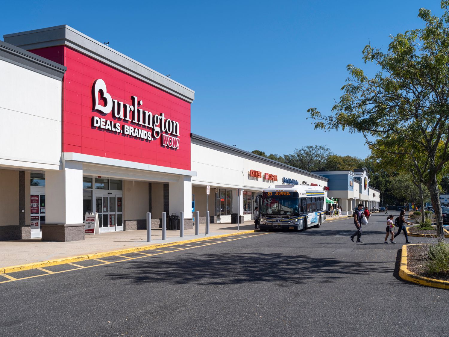 Burlington store with bus and shoppers in the crosswalk.