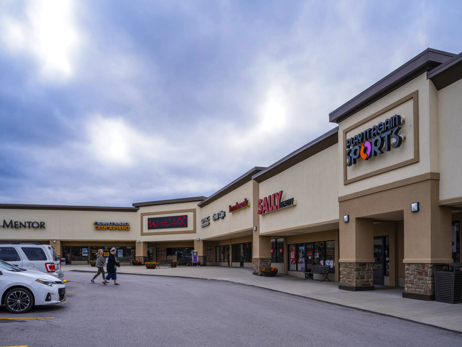 Play it Again Sports and Sally Beauty with 2 patrons approaching from parking lot.