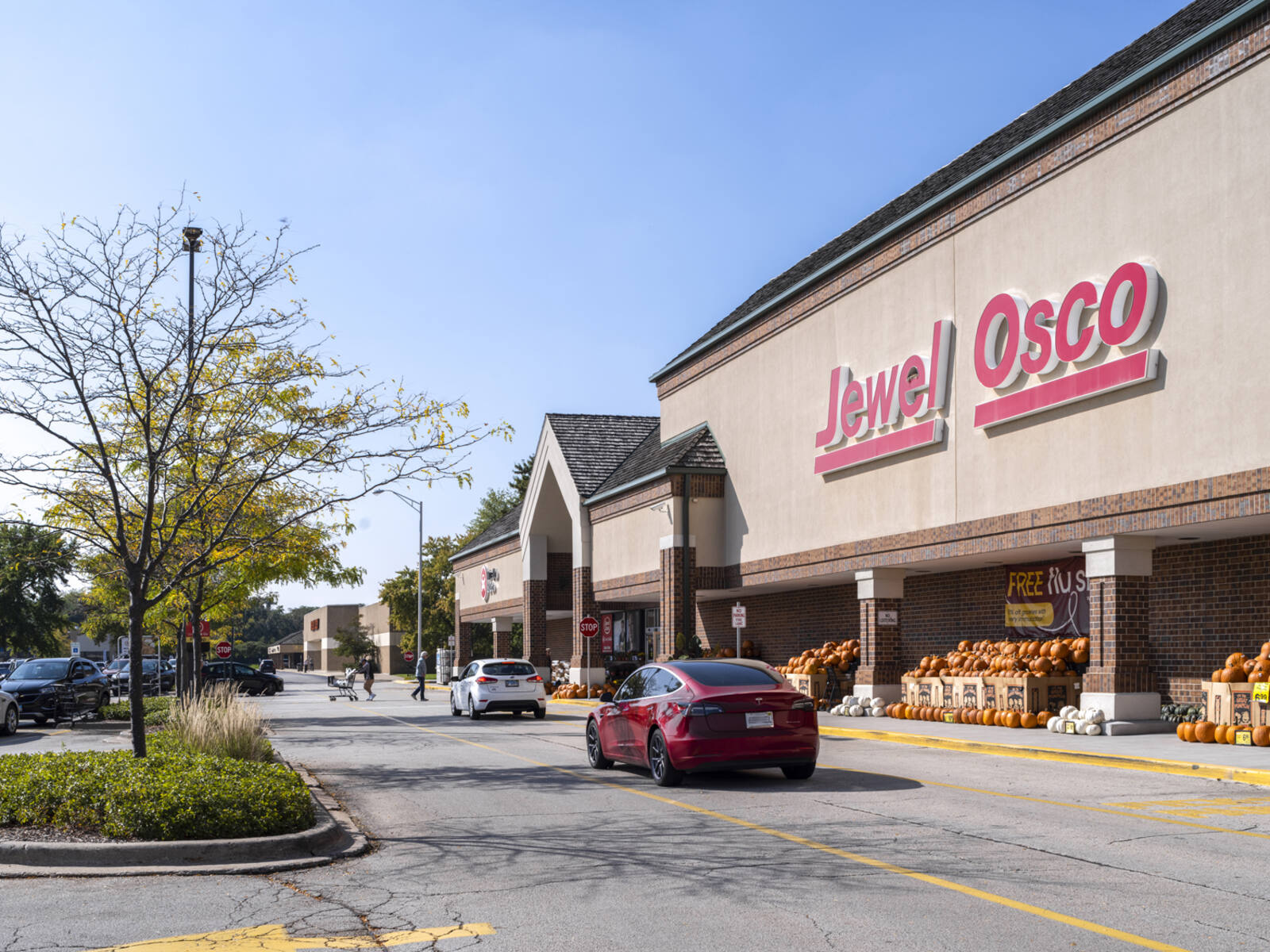 Cars and pedestrians in a busy crosswalk for Jewel Osco supermarket.