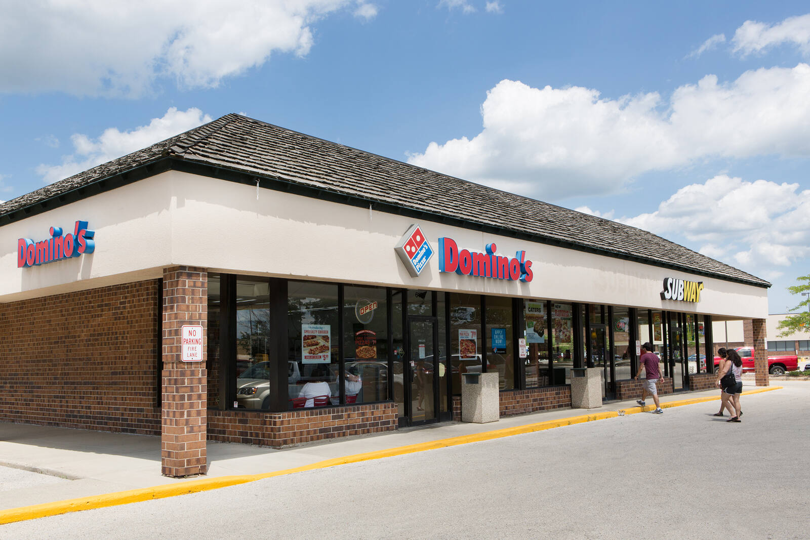 two people walking towards the entrance of Domino's at The Commons of Crystal Lake