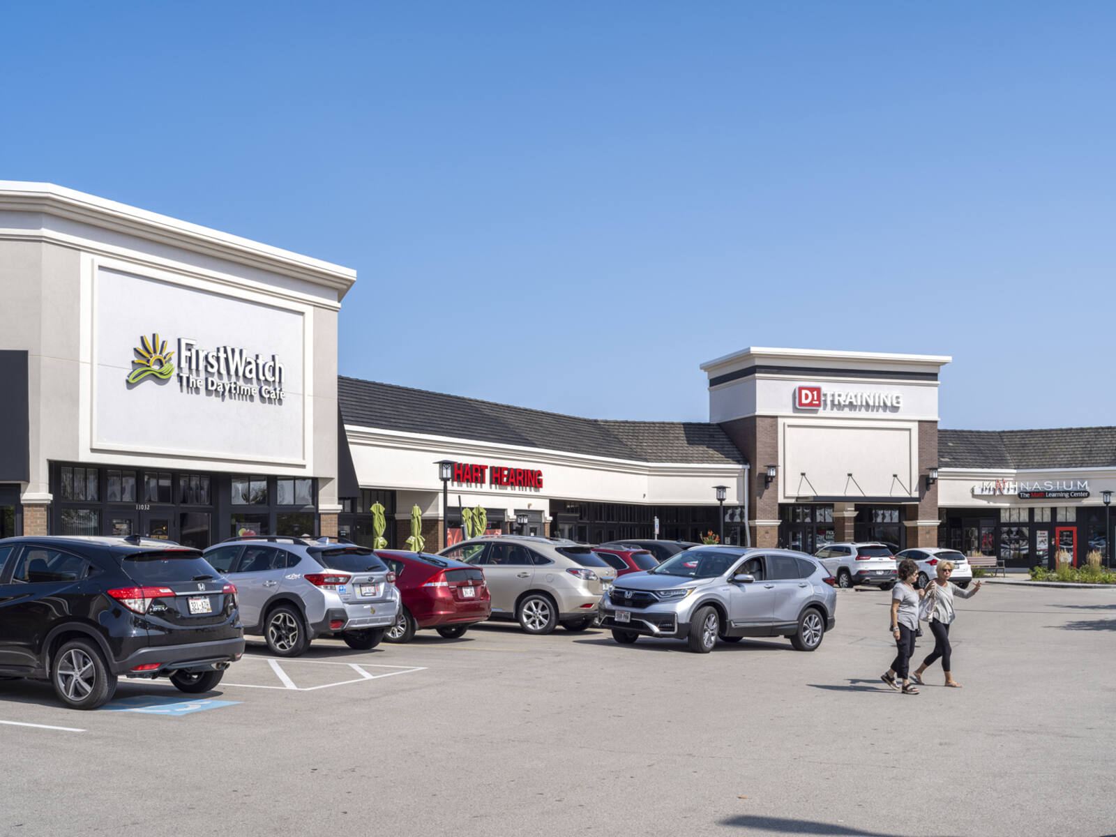 Two women in busy parking lot for FirstWatch and D1 Training.