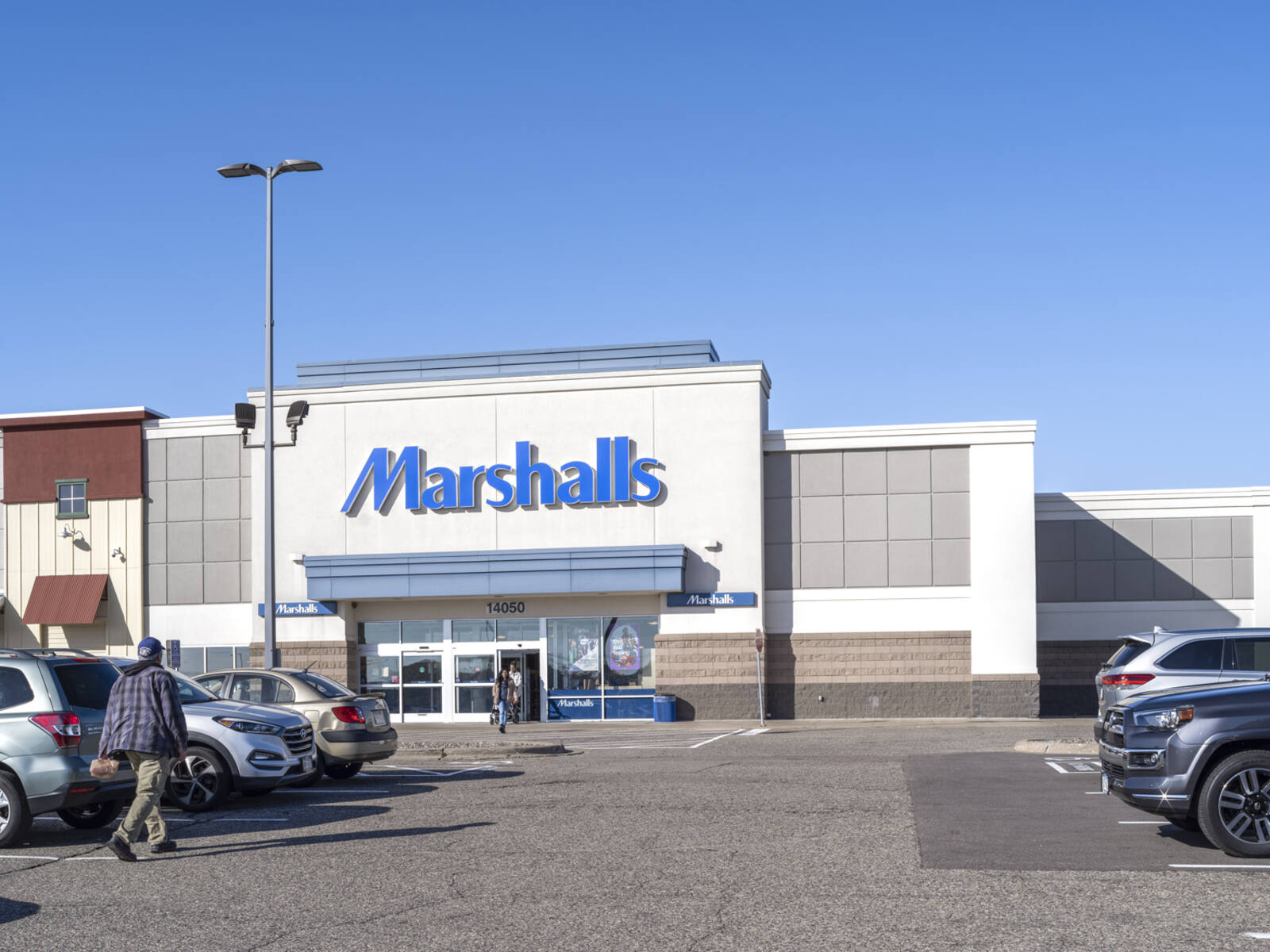 Patrons entering and exiting Marshalls through the parking lot.