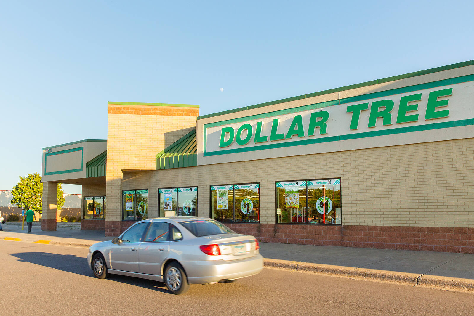 Silver car driving along entrance of Dollar Tree