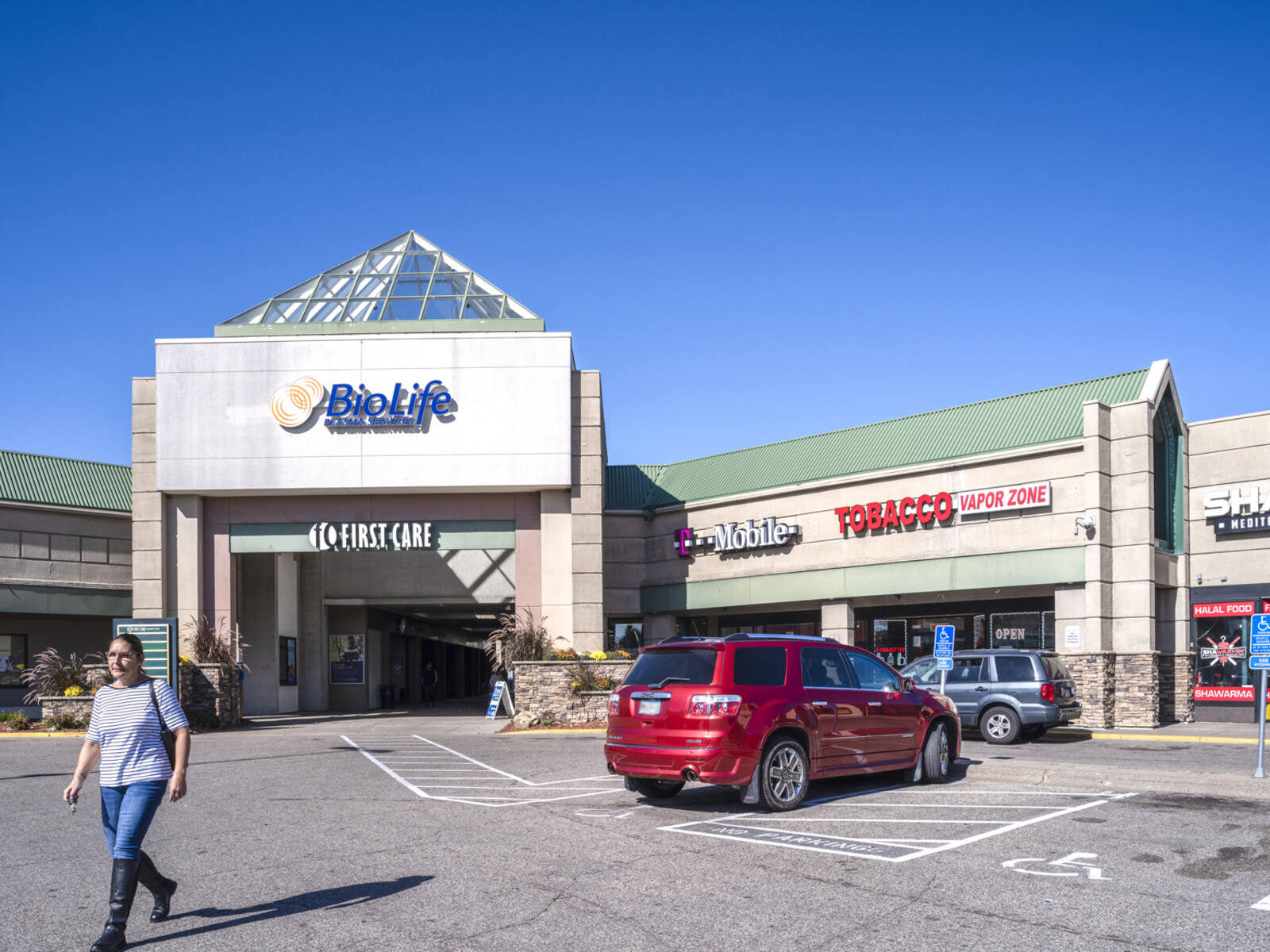 Woman leaving parking lot of T-Mobile and BioLife.