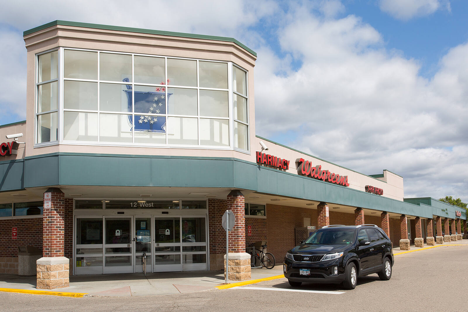 Black SUV at front of Walgreens at outdoor shopping center