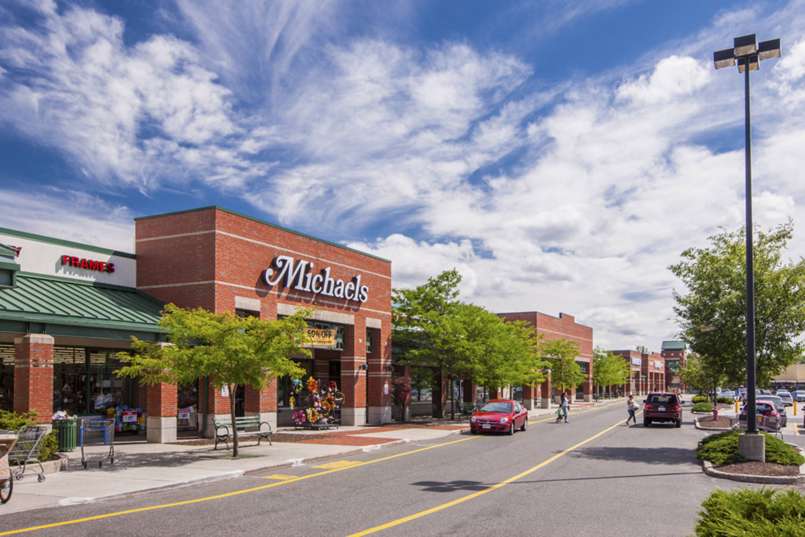Trees and a blue cloudy sky surround a Michaels art store at Pittsfield, MA.