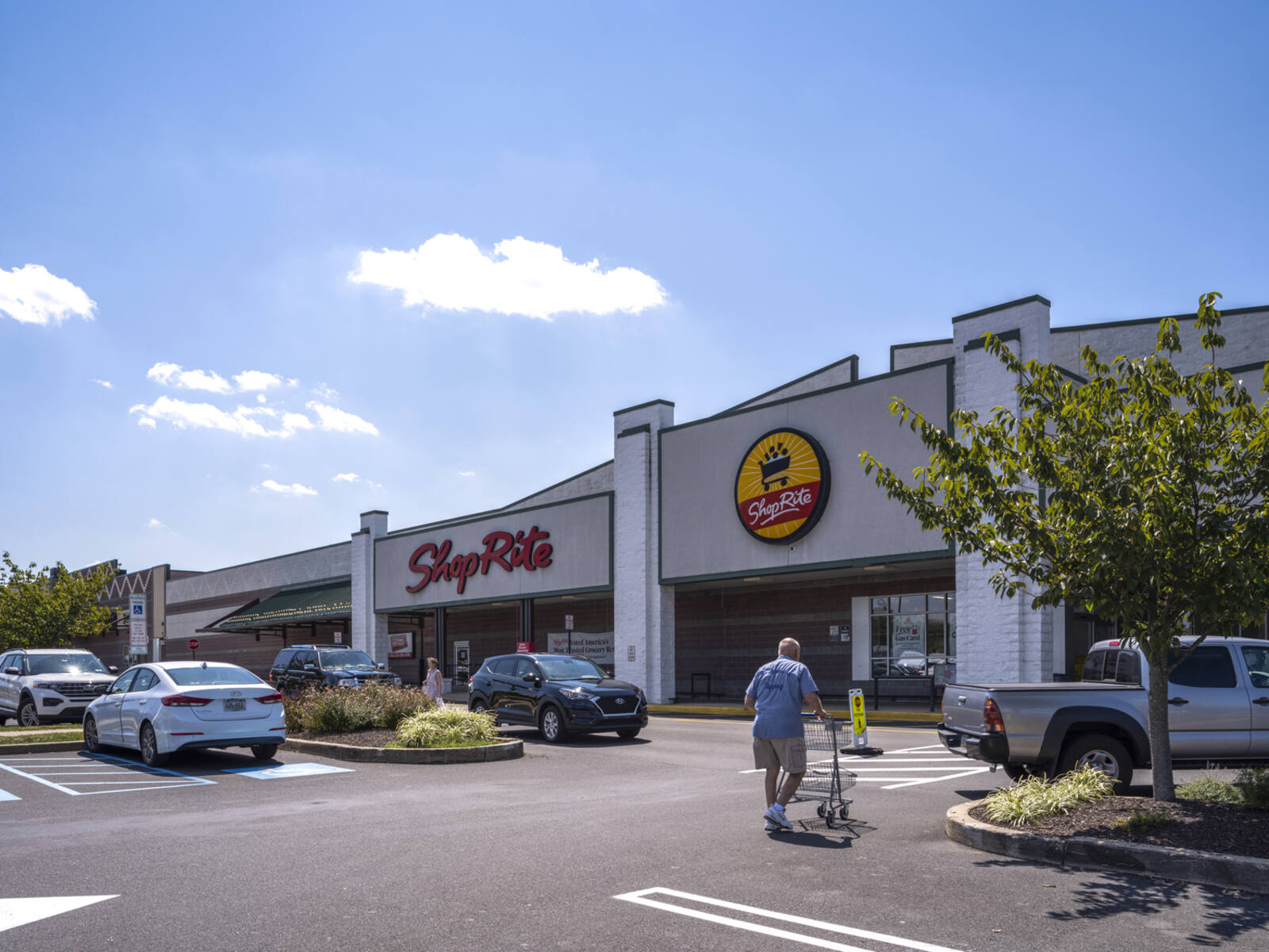 Customer with cart entering ShopRite grocery store.