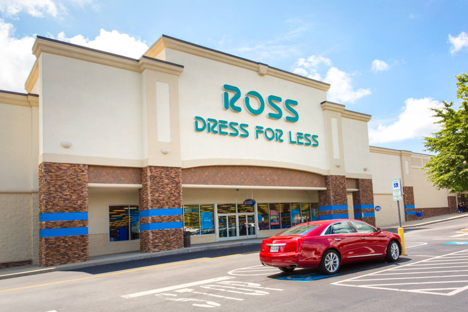 Ross Dress for Less department store with red car passing at the storefront.