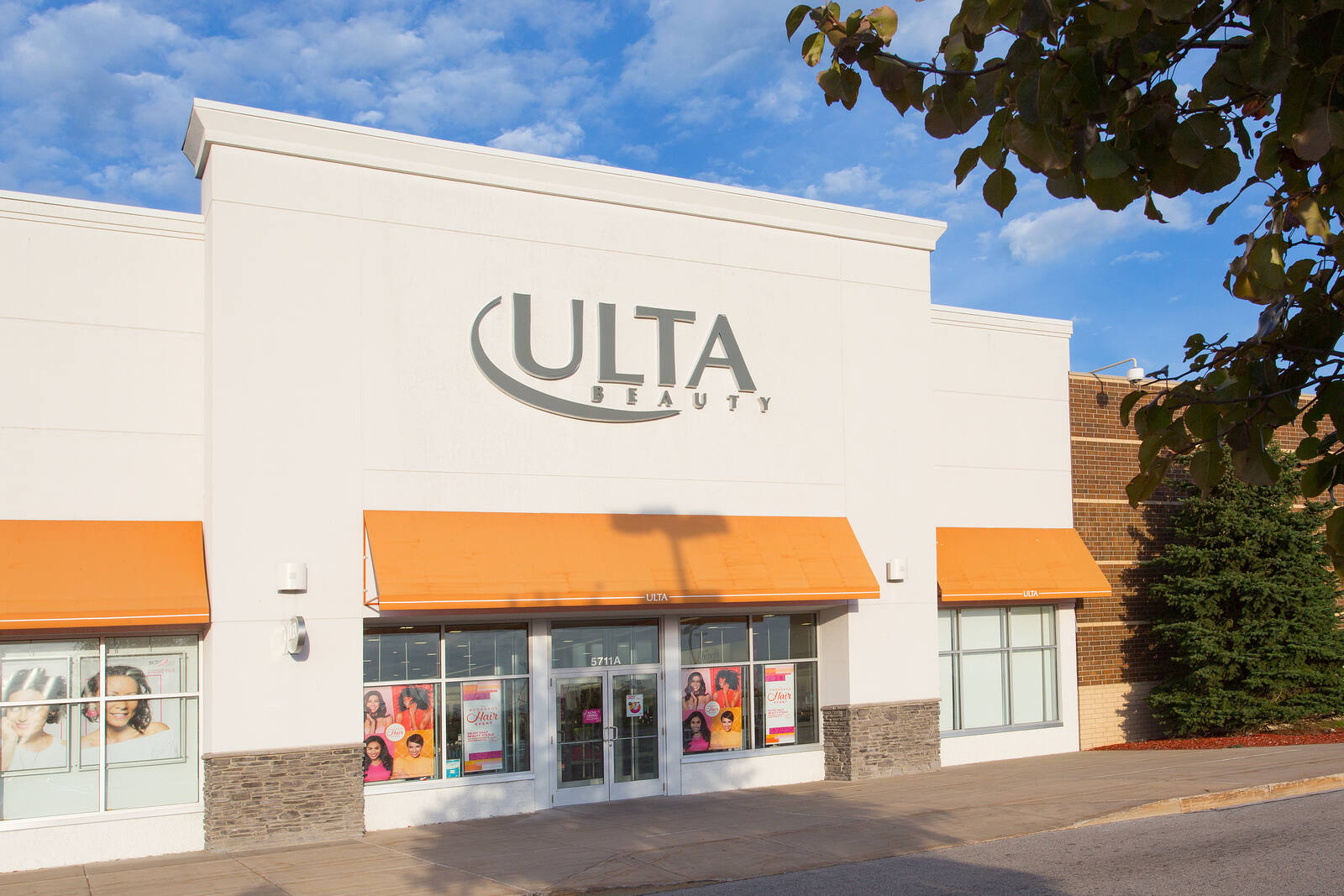 Green trees on the right of the entrance to Ulta at Lakes Crossing shopping center