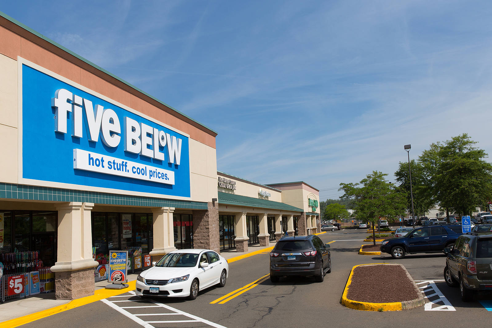 Two cars passing Five Below storefront at North Haven Crossing.