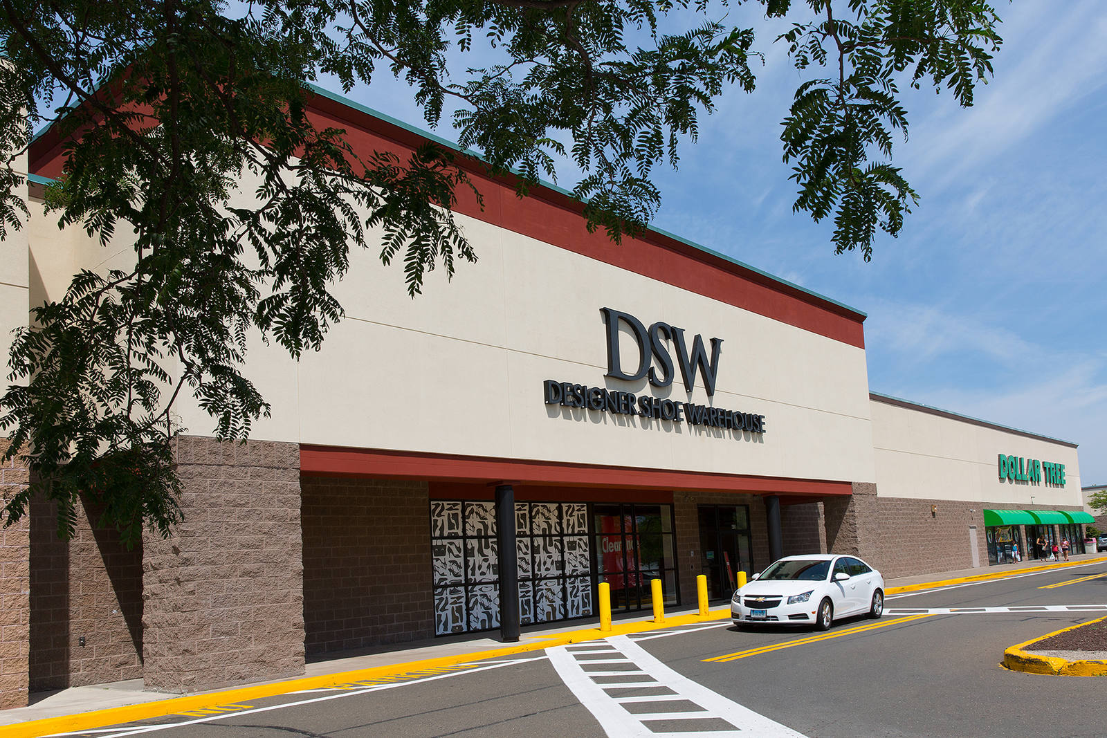 DSW shoe store with tree branches hanging over storefront in North Haven, CT.