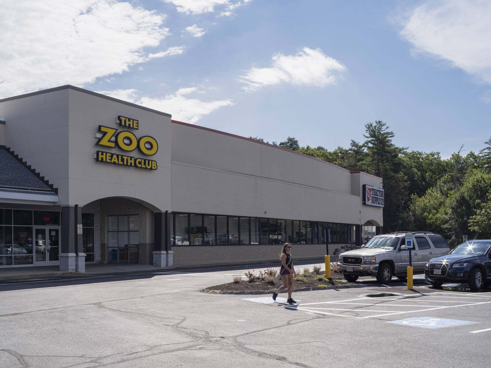 Person walking through parking lot at entrance of The Zoo Health Club