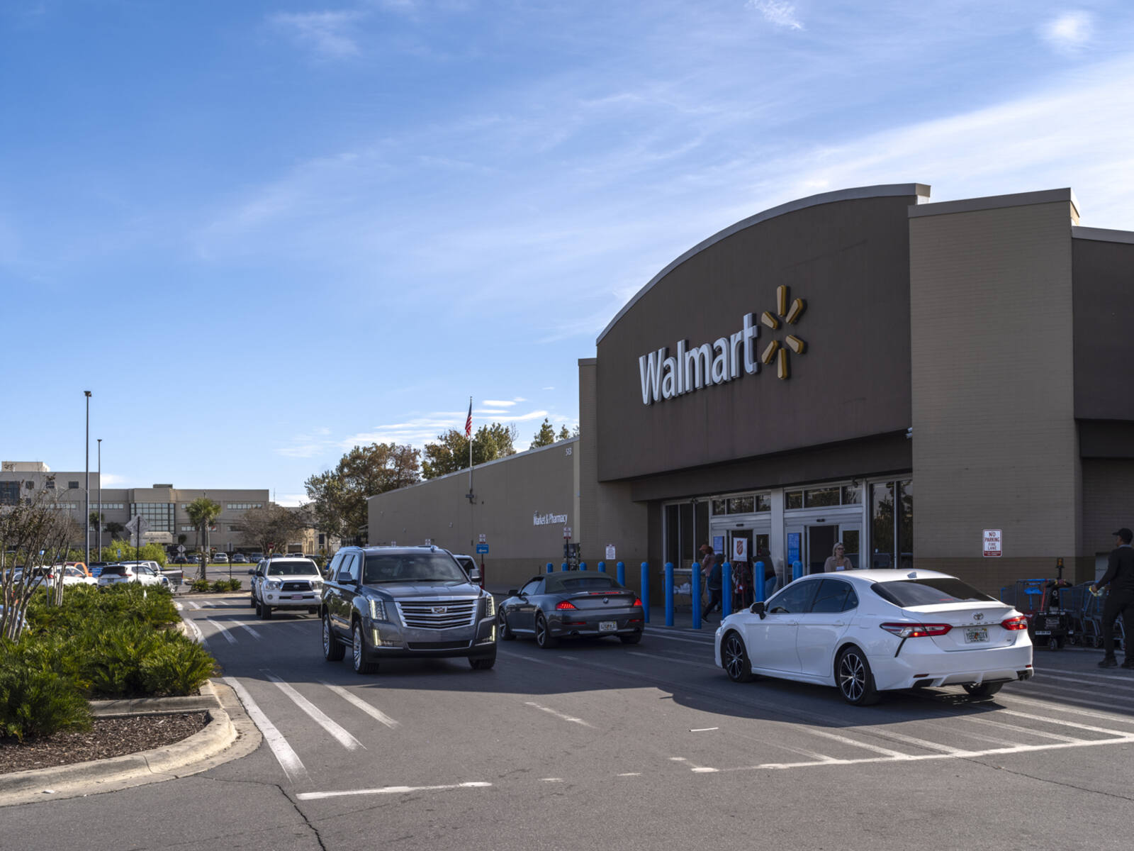 Busy intersection of cars in crosswalk in front of Walmart store.