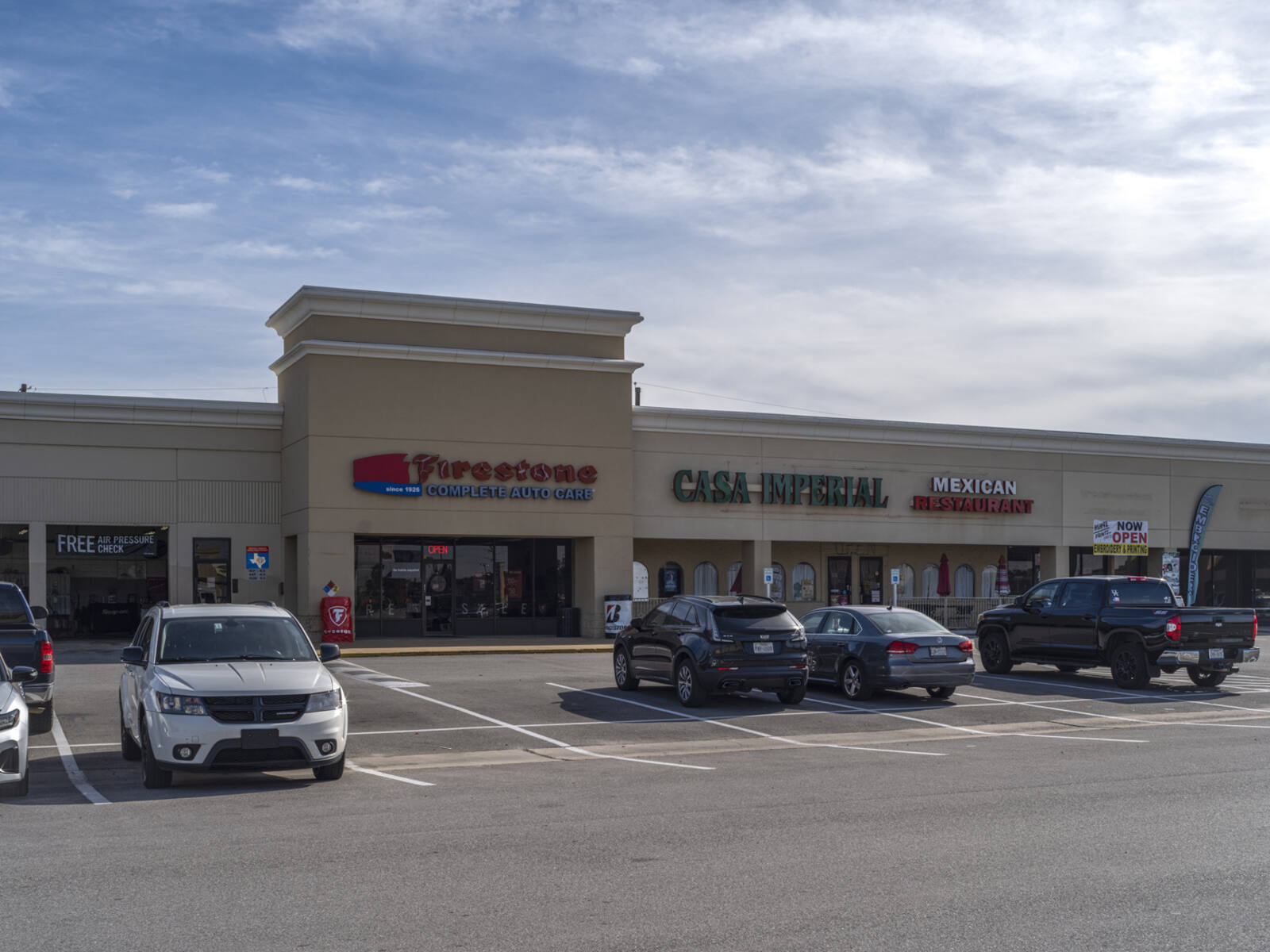 Row of parked cars in front of Firestone auto care store.