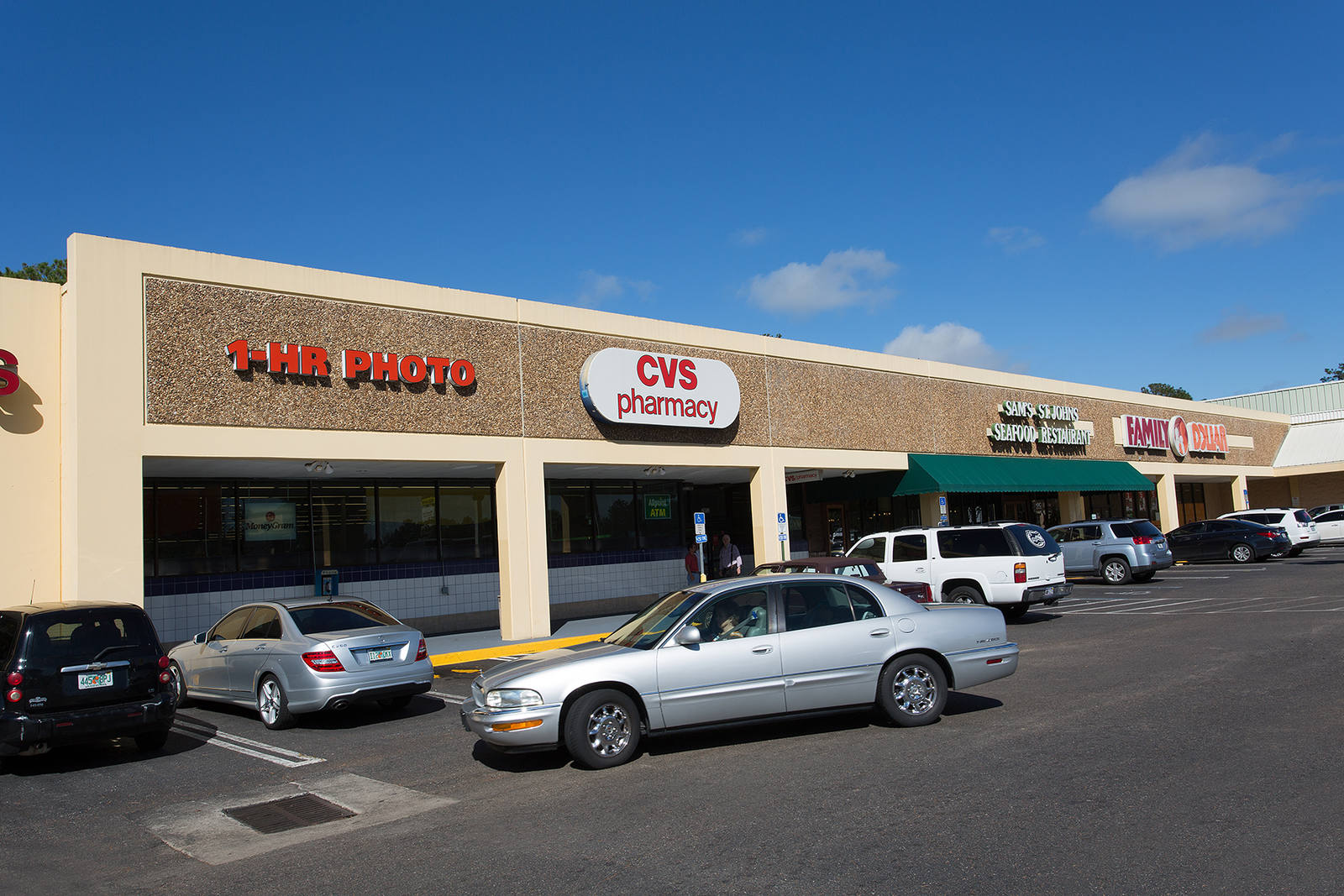 Grey car exiting parking lot at CVS Pharmacy at Normandy Square.