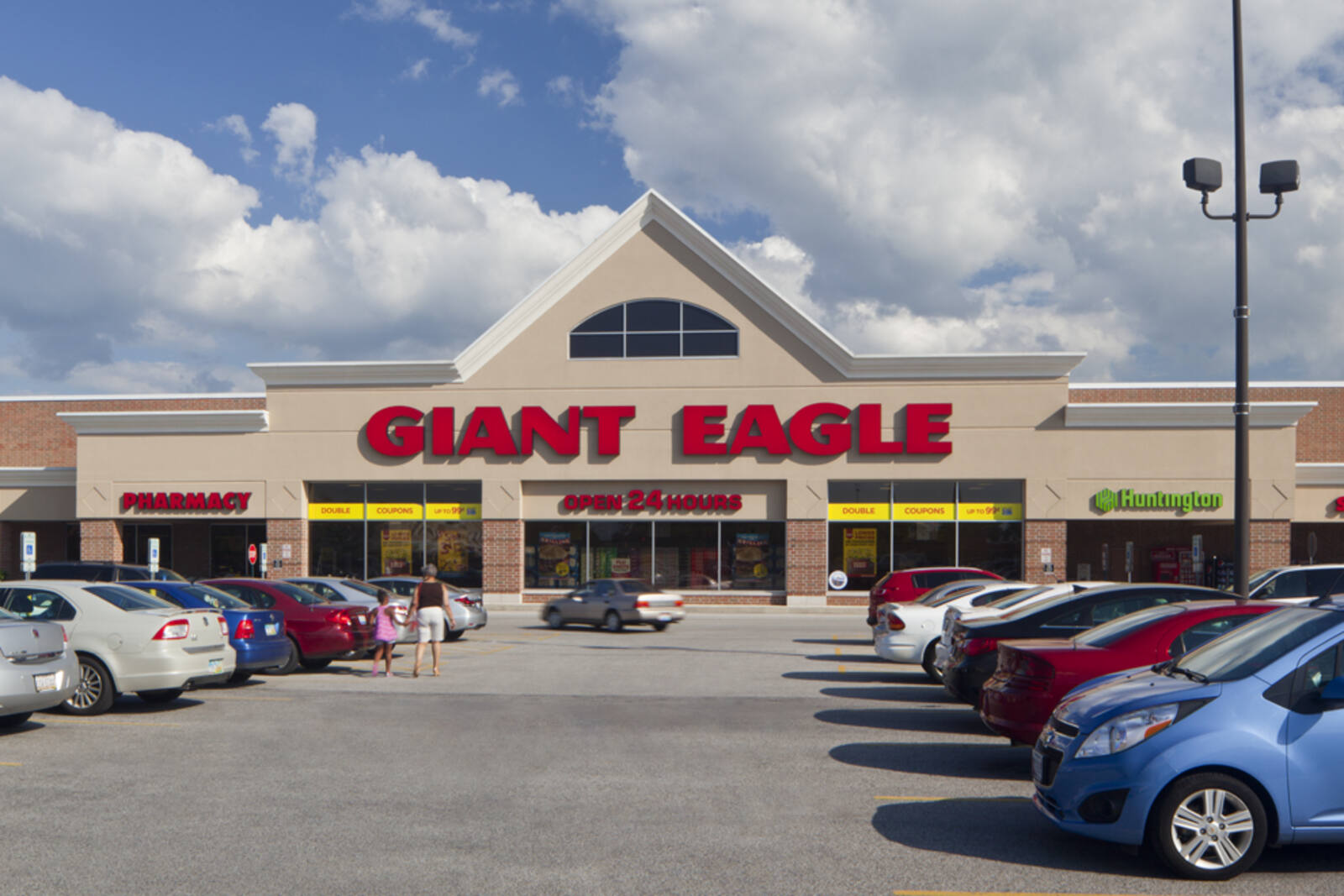 Cars lining parking lot on either side of entrance to Giant Eagle