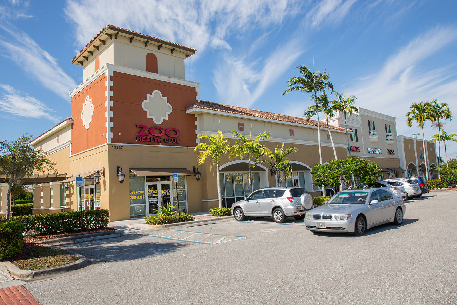 Grey car passing lot at Zoo Health Club gym in Cobblestone Village.