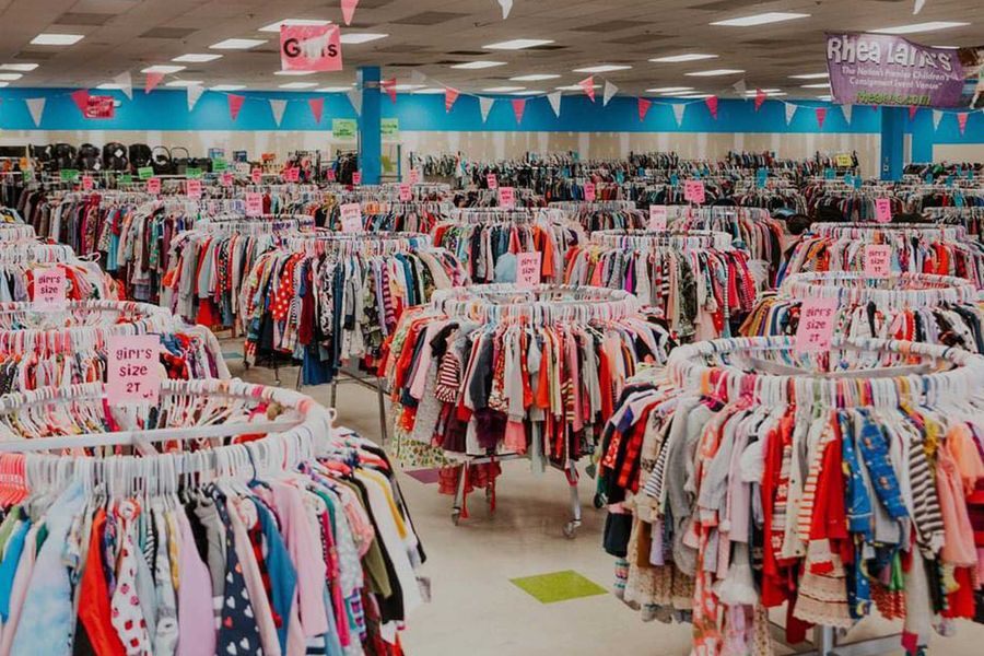 Indoor space with rows of clothing racks filled with colorful children's clothing