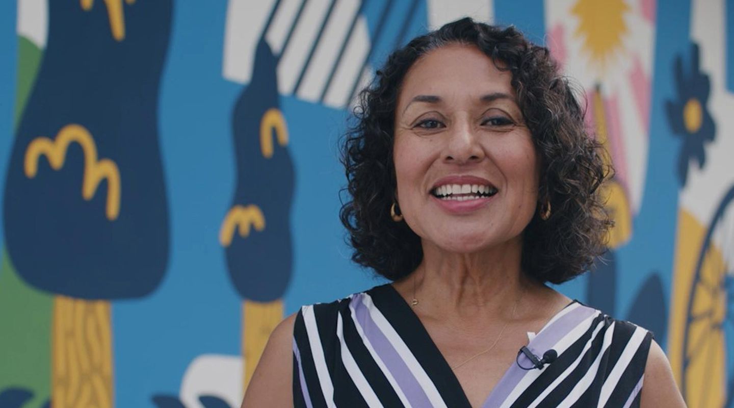 Close up of Councilmember Gloria Partida from Davis CA with a mural behind her