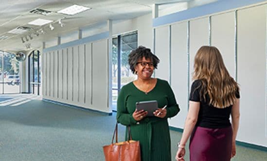 Female leasing agent showing a vacant space to a small business owner