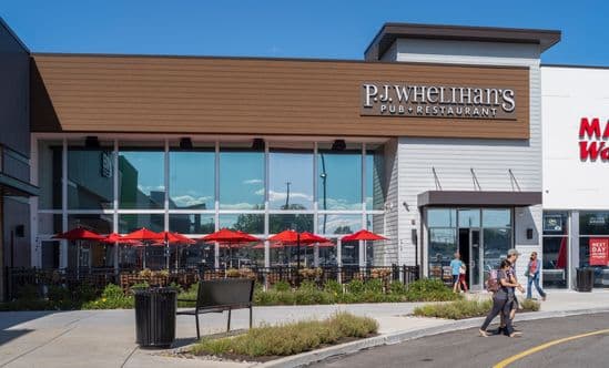 View of exterior storefront for P.J. Whelihan's restaurant with outdoor dining at Plymouth Square Shopping Center