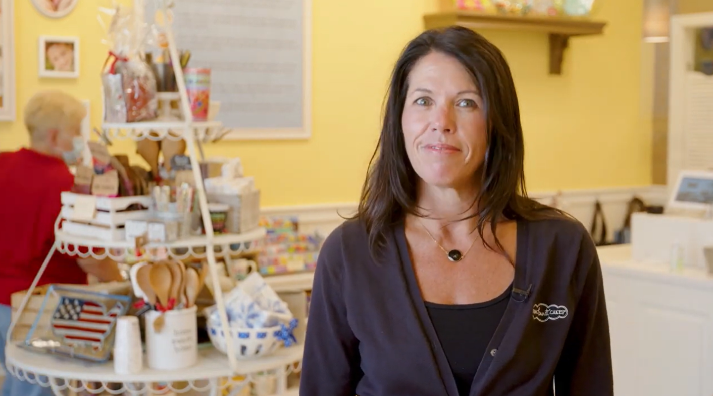 brunette woman standing in nothing bundt cakes shop with yellow walls
